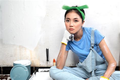 Азиатская молодая домохозяйка в перчатке с несчастным выражением лица Премиум Фото