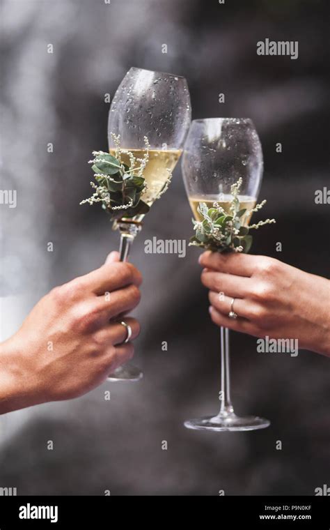 Man And Woman Hands Holding Two Champagne Glasses Decorated With