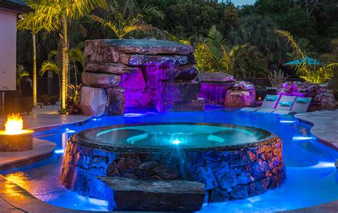 A Lagoon Pool And Floating Spa With Natural Stone Grotto Fire Pit And