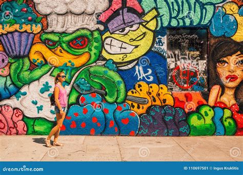Young Girl Standing By The Colorful Graffiti Wall In Los Angeles