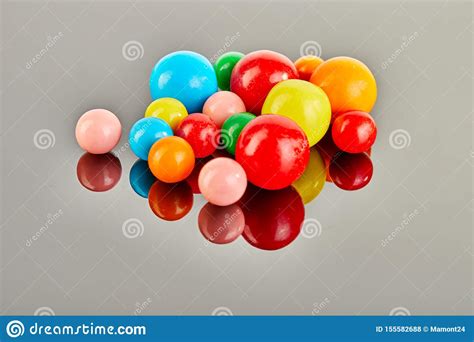 Multi Colored Balls Of Chewing Gum On A Gray Background With Reflection