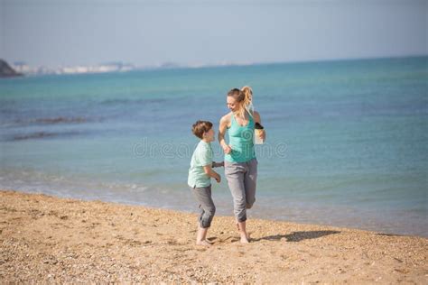 Madre Con El Hijo Que Corre En La Playa Foto De Archivo Imagen De