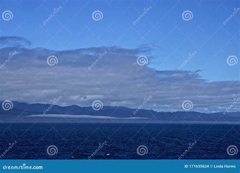 Morning At Sea Clouds And Fog In A Deep Blue Sky Over Alaskan Islands