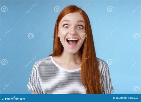 surprised pleased happy impressed redhead european girl 20s reacting amused wide eyes look