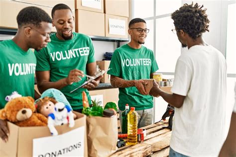 Group Of Young African American Volunteers Helping People At Charity