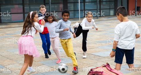 Feliz Preadolescente Niñas Y Niños Jugando Al Fútbol En El Patio De La Escuela Foto De Stock Y