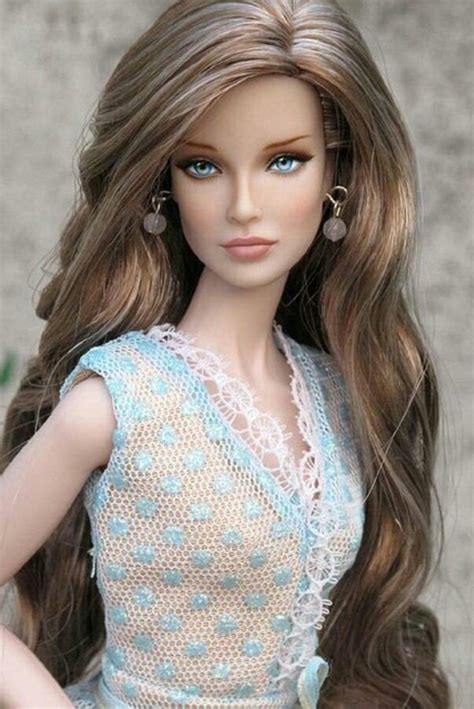 A Doll With Long Brown Hair Wearing A Blue Dress