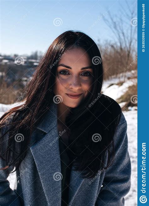 Portrait Of A Beautiful Dark Haired Girl With Brown Eyes On The Street In Snowy Winter Stock