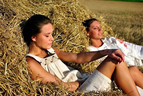 Two Girls In Traditional Russian Costume Resting On A Haystack Stock
