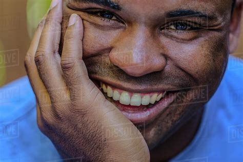 Close Up Of Smiling Black Man Resting Chin In Hand Stock Photo Dissolve