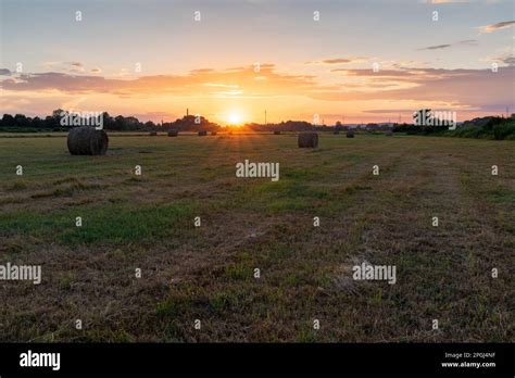 Round Hay Bales On Field At Golden Sunset Sunset In Countryside With