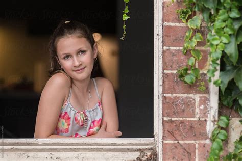 Portrait Of A Teen Girl In A Window Del Colaborador De Stocksy
