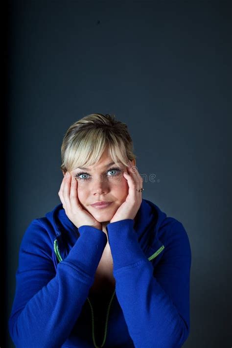 Studio Portrait Of A Cute Blond Girl Bored With Heads In Hands Stock