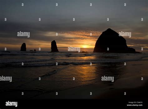 Sunset Over Haystack Rock In Cannon Beach At Oregon Coast Stock Photo