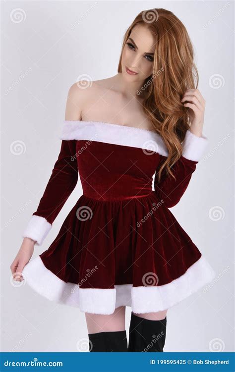Beautiful Tall Slim Busty Redhead Model Dressed As A Santa Elf And Helpers Stock Image