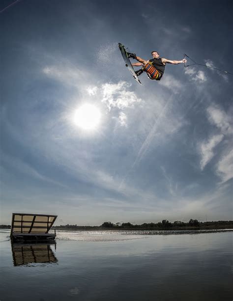 A Man Flying Through The Air While Riding Skis On Top Of A Body Of Water