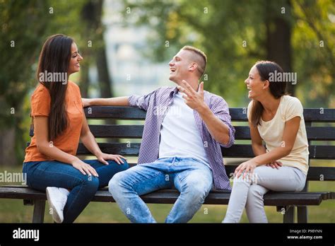 Three Friends Are Sitting On Bench In Park And Talking Stock Photo Alamy