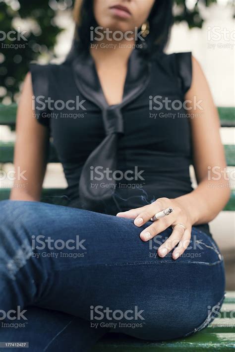 Young Woman Smoking Cigarette On Bench Stock Photo Download Image Now