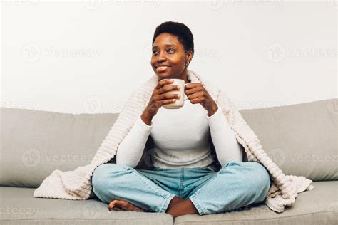 Person Sitting On A Sofa And Drinking Coffee Stock Photo At