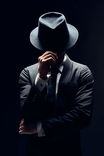 暗い背景に孤立した彼の帽子の後ろの顔を隠してスーツを着た男 男性のストックフォトや画像を多数ご用意 男性 帽子 マフィア Istock