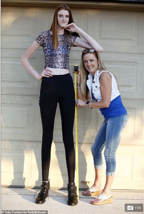Two Women Standing Next To Each Other In Front Of A Garage Door With A