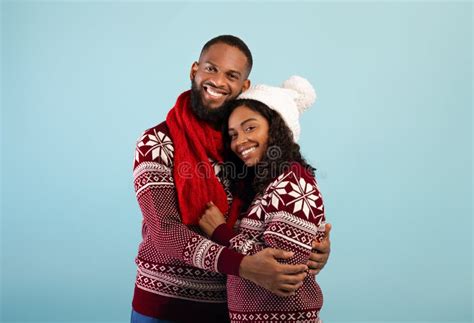 Excited African American Couple In Christmas Sweaters Hugging And