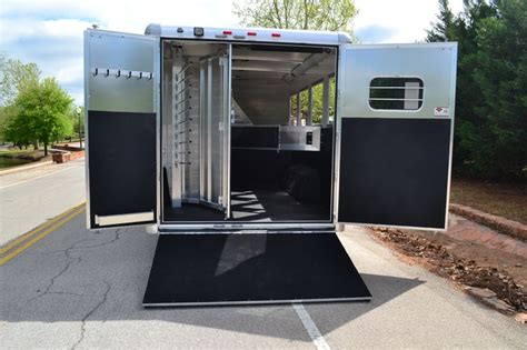 A Horse Trailer Is Parked On The Side Of The Road With Its Door Open