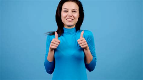 Positive Joyful Cheerful Woman Showing Thumbs Up On Blue Background In