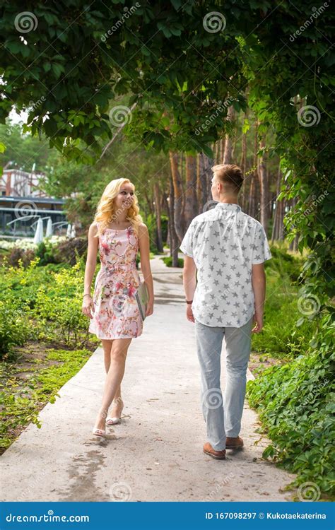 Young Guy And Girl Meet On A Narrow Path In The Garden Stock Image