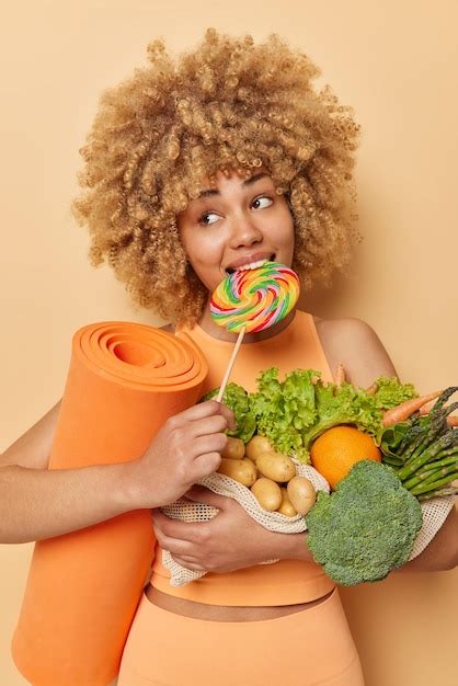 Premium Photo Vertical Shot Of Pensive Curly Haired Woman Breaks Diet
