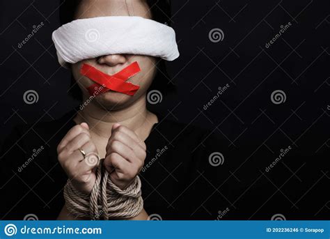 Woman Blindfold Wrapping Mouth With Red Adhesive Tape Tied With Chains And Closed Her Eyes
