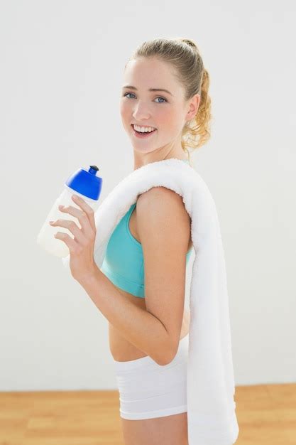 Premium Photo Smiling Slim Blonde Standing And Holding Sports Bottle