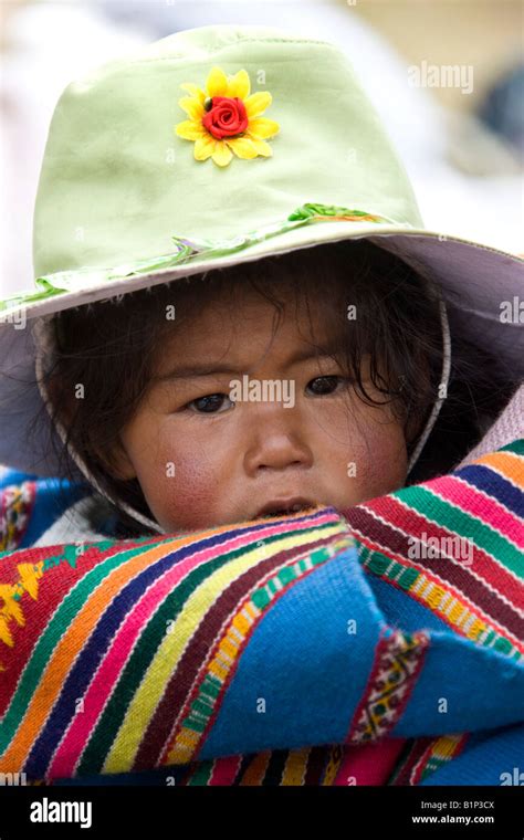 Peruvian Child Being Carried On Her Mothers Back In Puno In Southern