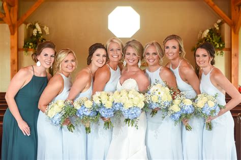 A Group Of Women Standing Next To Each Other In Front Of A Wooden