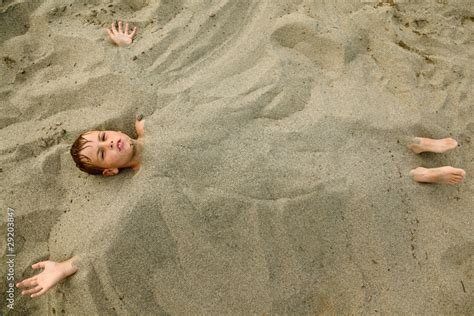 Boy After Swimming Is Buried In Sand On Beach Stock Photo Adobe Stock