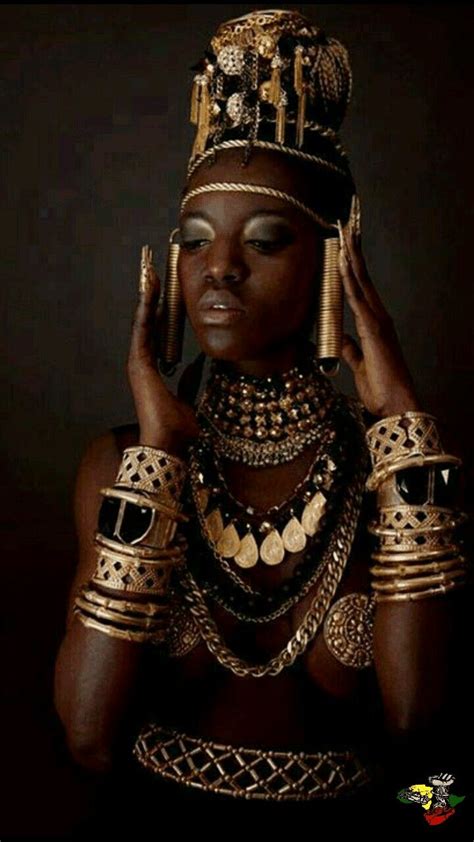 An African Woman Wearing Gold Jewelry And Holding Her Hands Up To Her Face With Both Hands