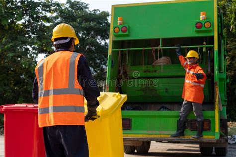 Two Asian Garbage Men Working Together On Emptying Dustbins For Trash Removal Garbage Collector