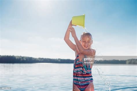 Portrait Of Smiling Girl Pouring Water Over Her Head Bildbanksbilder Getty Images