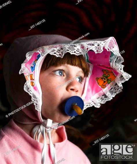 Young Girl Of 6 Dressed Up As A Baby With Pacifier In Her Mouth Stock