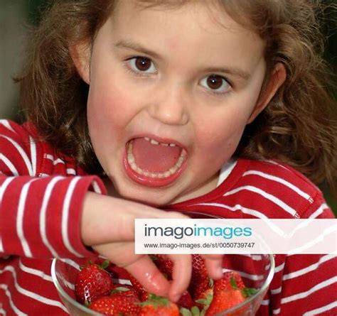 kleines mädchen lässt sich saftige erdbeeren schmecken
