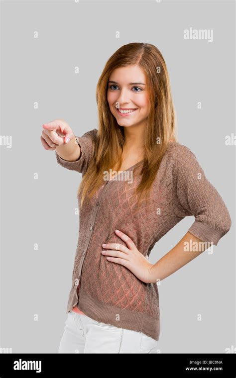 Beautiful Blonde Woman Pointing Somewhere Isolated Over A Gray