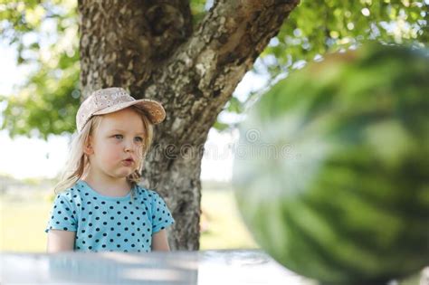 Cute Little Girl Eating Watermelon Outdoors In Summertime Child And