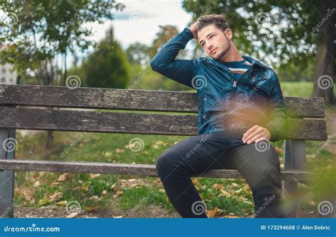 Young Man Sitting In A Park On The Bench Handsome Guy Relaxing Stock