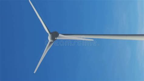 Close Shot Of Wind Turbine Rotating Against Clear Blue Sky On Sunny Day