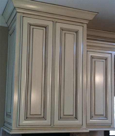 You can get an antique white cabinet by using the glaze, a thinned paint mixture to apply on the kitchen cabinets to get the effect you aim to. Cabinet-Glazing