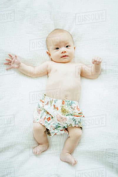 Portrait Of Mixed Race Baby Girl Laying On Blanket Stock Photo Dissolve