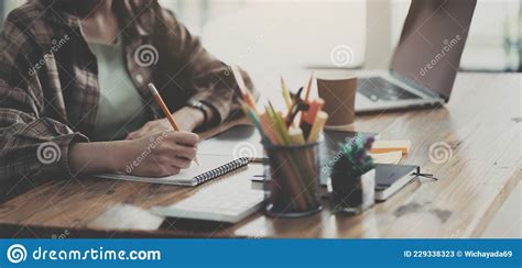 Hands Of Financial Manager Taking Notes When Working On Report Stock