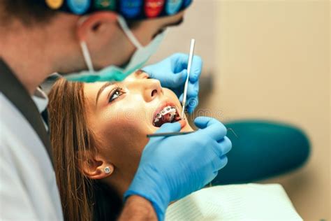 Dentist Examine Female Patient With Braces In Denal Office Stock Image
