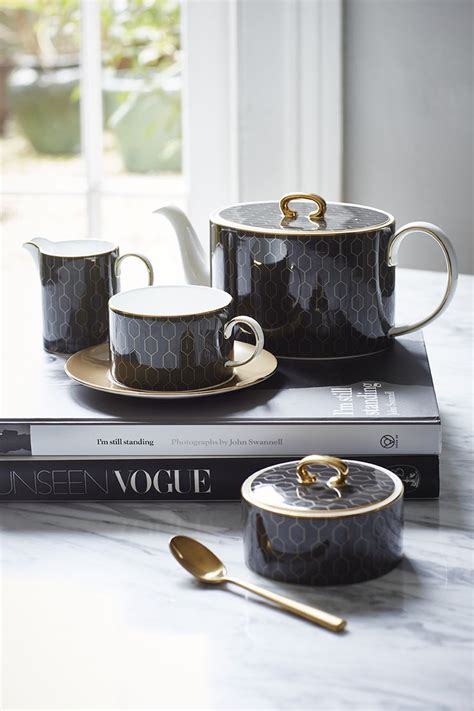 Two Coffee Cups And Saucers Sitting On Top Of A Book With Spoons Next