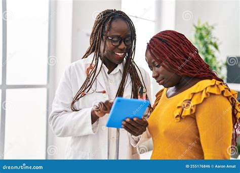 African American Women Doctor And Patient Using Touchpad Having